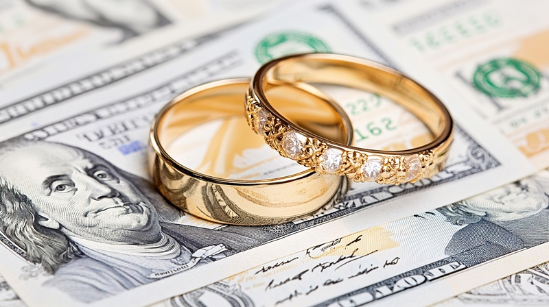Wedding rings lie on money. Concept of fictitious marriage with financial gain. Prenuptial Agreement Lawyer, Levy Craig Family Law Kansas City, Supports Financial Transparency in MarriageAdobeStock_1542200103